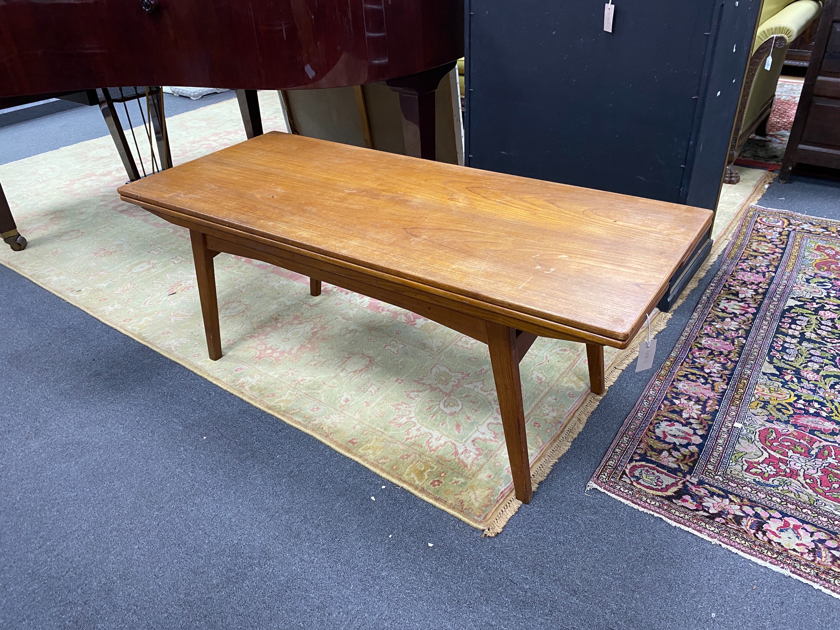 A Danish rectangular teak metamorphic coffee / dining table by Niels Bach, smallest dimensions width 140cm, depth 60cm, height 56cm